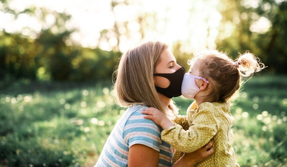 Mother Kissing Daughter With Masks