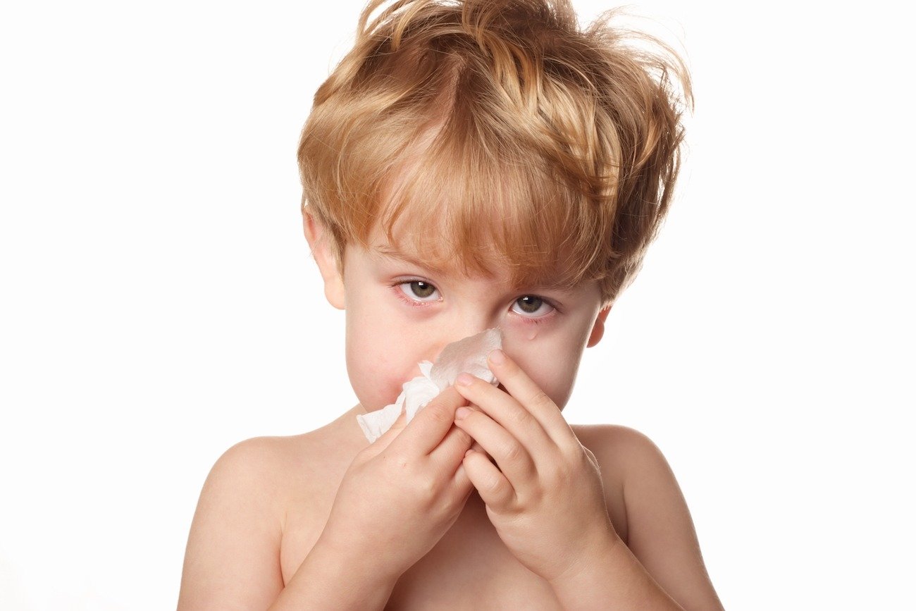 Young boy sneezing and covering his mouth from RSV in Idaho Falls