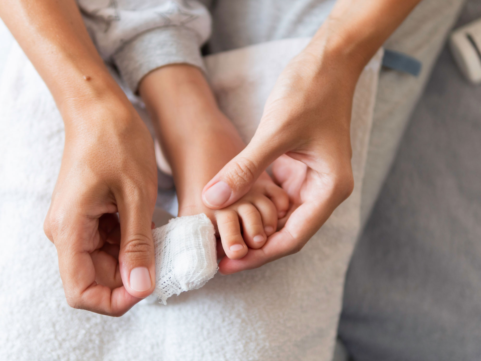 Mother Bandages her Child S Big Toe First Aid in